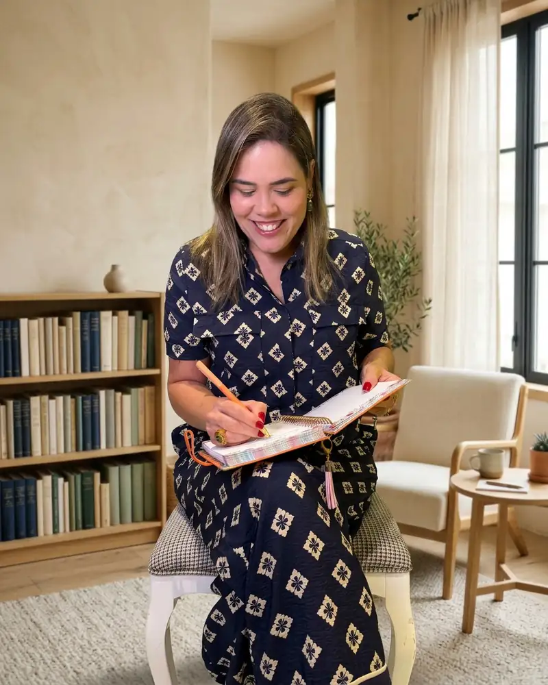 Daniella Xavier sentada, escrevendo em um caderno